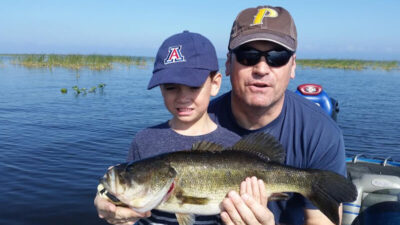 A fishing guide assisting a client on a boat at Beaver Lake