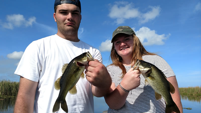 Two anglers holding Lake Okeechobee bass during a November trip