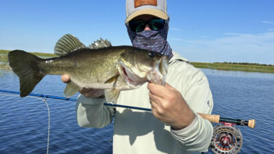 A fly fishing charter in action, with a guide and anglers on a boat.