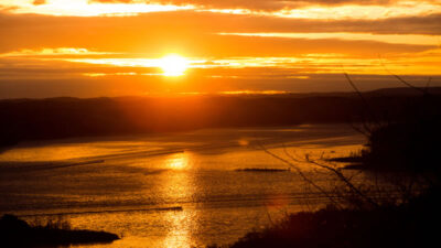 Beaver Lake Fishing Guides 5 Illustration of a serene sunset at Beaver Lake, ideal for striped bass fishing